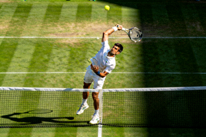 德约科维奇在草地上发球瞬间