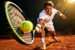 网球运动员在红土场上挥拍击球瞬间